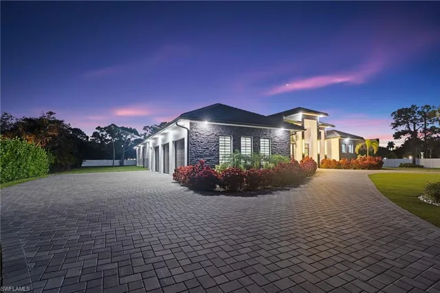 a front view of a house with yard and green space