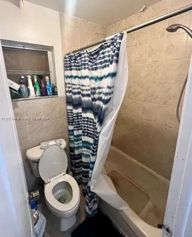 a bathroom with a toilet and a shower
