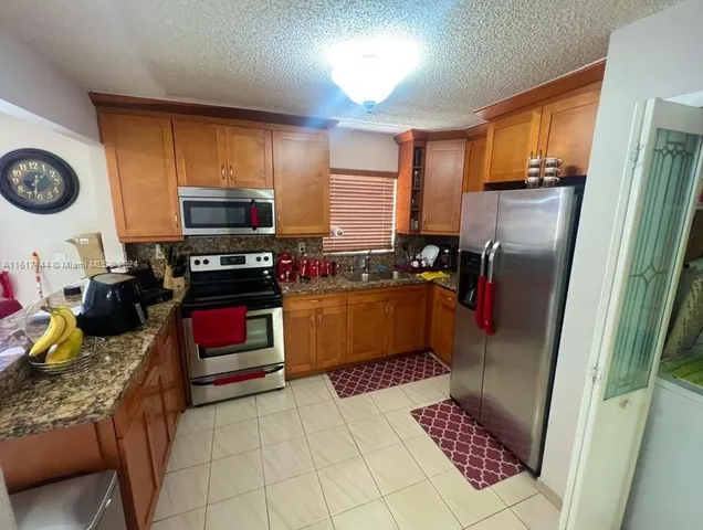 a kitchen with stainless steel appliances wooden cabinets and a stove top oven