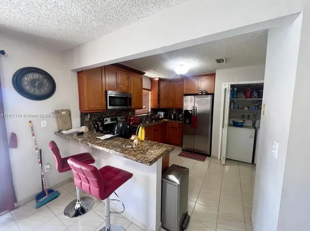 a kitchen with stainless steel appliances granite countertop a refrigerator stove top oven a sink and dishwasher