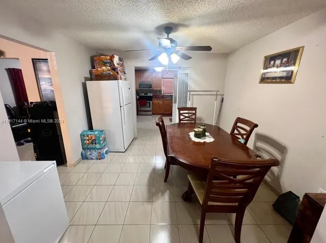 a view of a dining room with furniture and a chandelier fan
