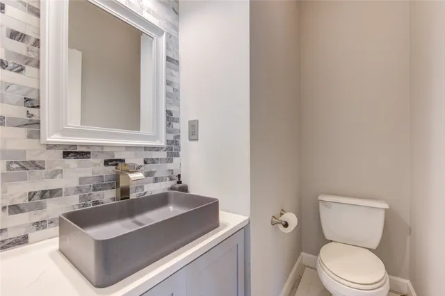 a bathroom with a sink a toilet and mirror