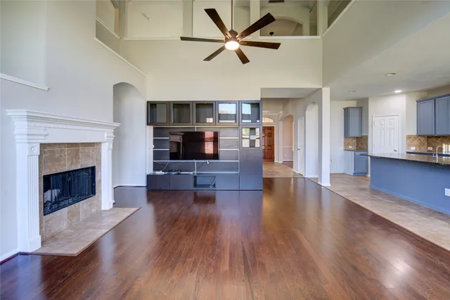 a living room with stainless steel appliances furniture a fireplace and wooden floor