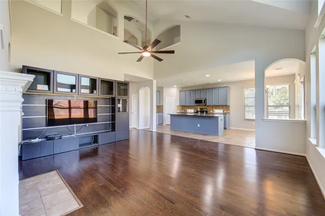 a view of an empty room with window and wooden floor
