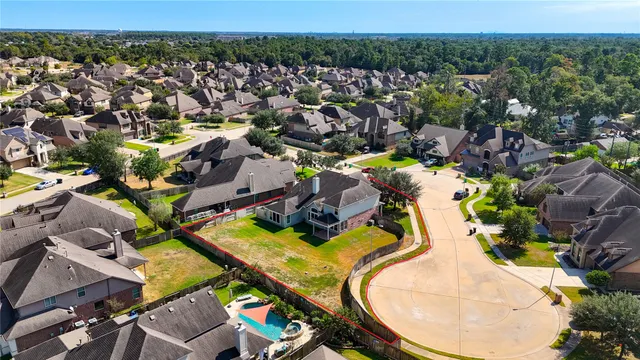 an aerial view of a house with a swimming pool and lake view