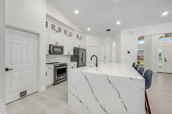 a bathroom with a granite countertop toilet a sink and a mirror