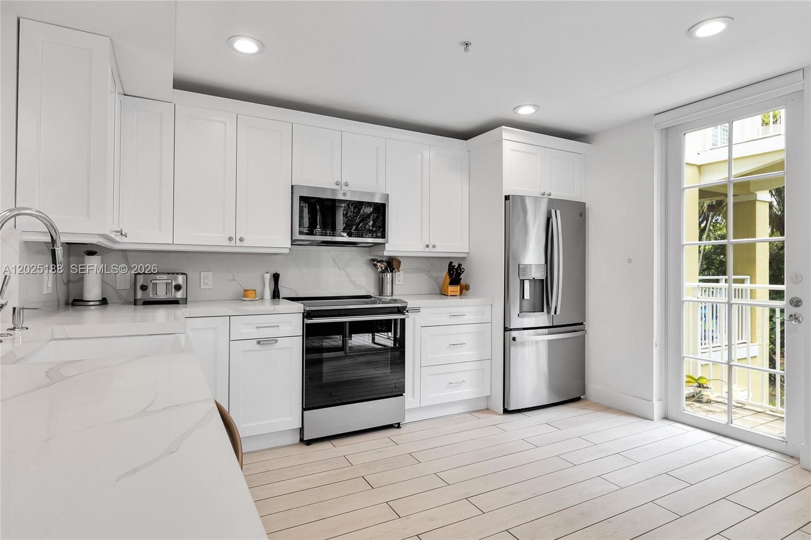 7620 Southwest 102nd Street, Unit 121 Pinecrest, FL 33156 - Photo 4 of 18 a kitchen with stainless steel appliances a refrigerator stove and microwave