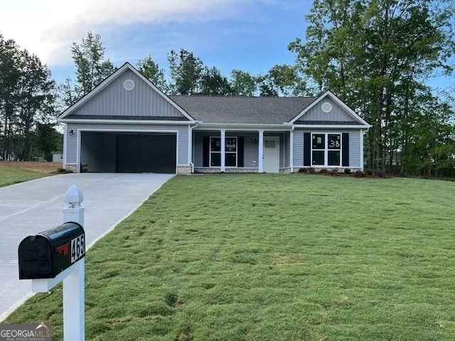 a front view of a house with yard and trees