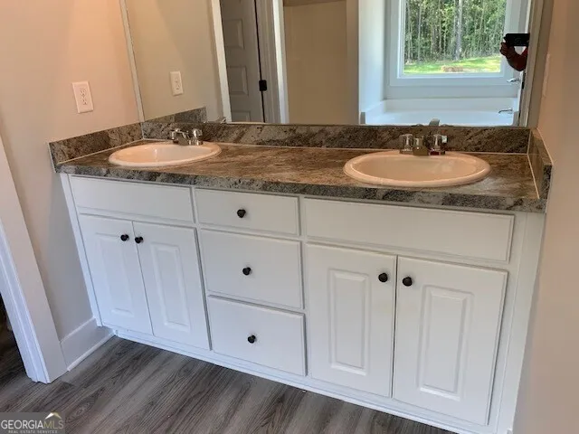 a bathroom with a granite countertop sink and a mirror