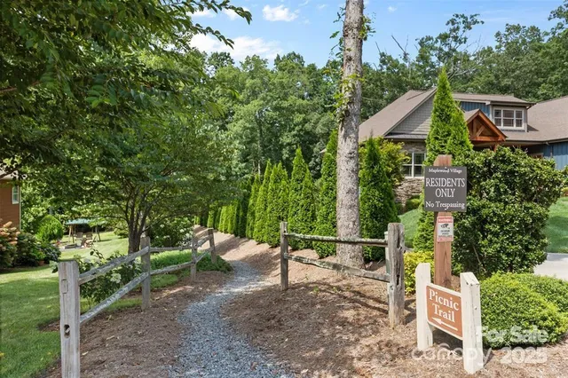 a backyard of a house with table and chairs under an umbrella