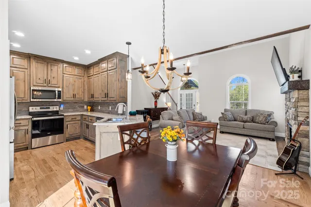 a living room with stainless steel appliances furniture or couch and a kitchen view