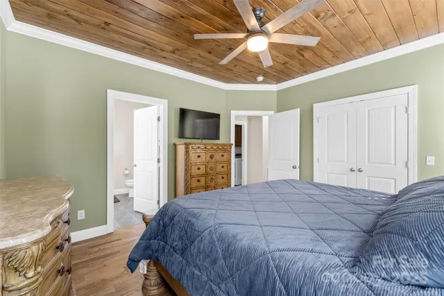 a bedroom with a bed closet and a flat tv screen