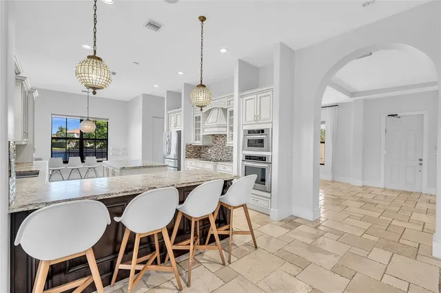 a kitchen with kitchen island granite countertop a stove and a center island