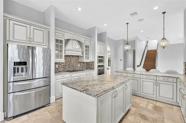 a kitchen with stainless steel appliances granite countertop a refrigerator and a sink