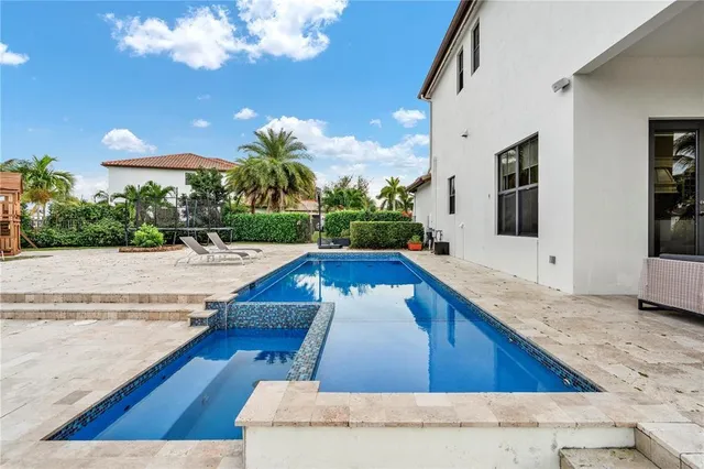 a living room with stainless steel appliances granite countertop furniture a fireplace a flat screen tv and a window