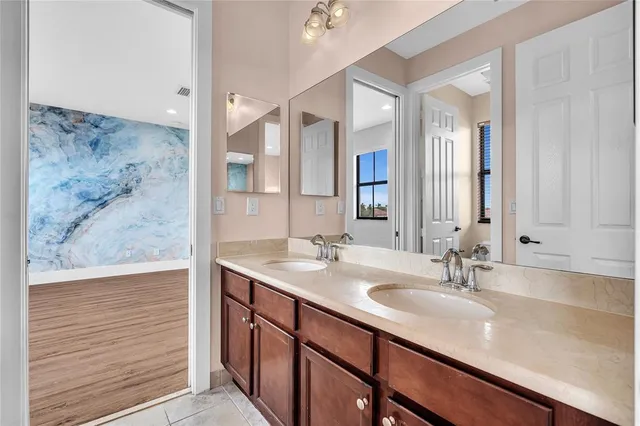 a spacious bathroom with a double vanity sink large mirror and bathtub