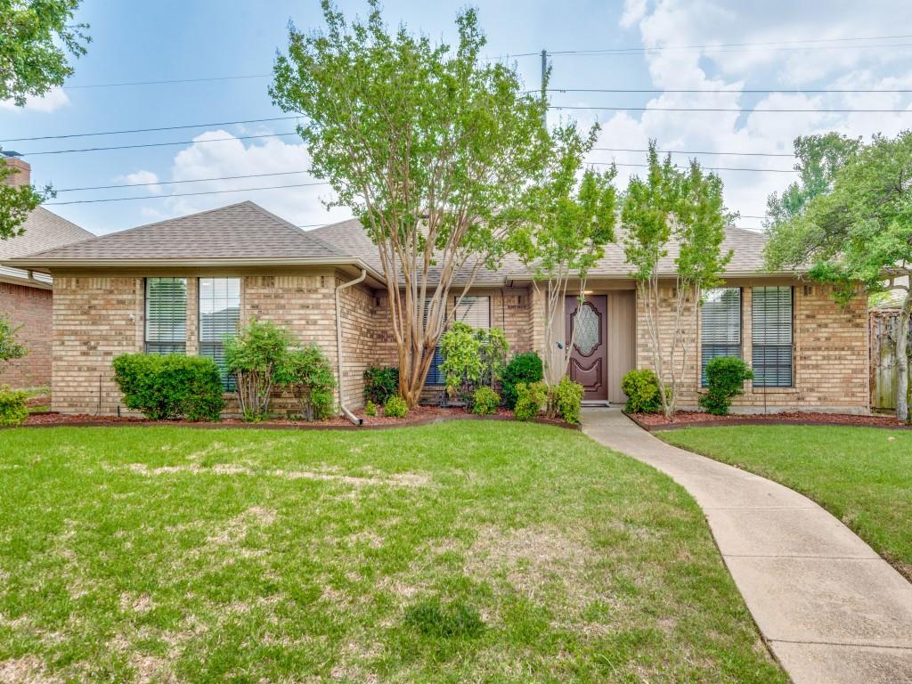 a front view of a house with a yard and potted plants