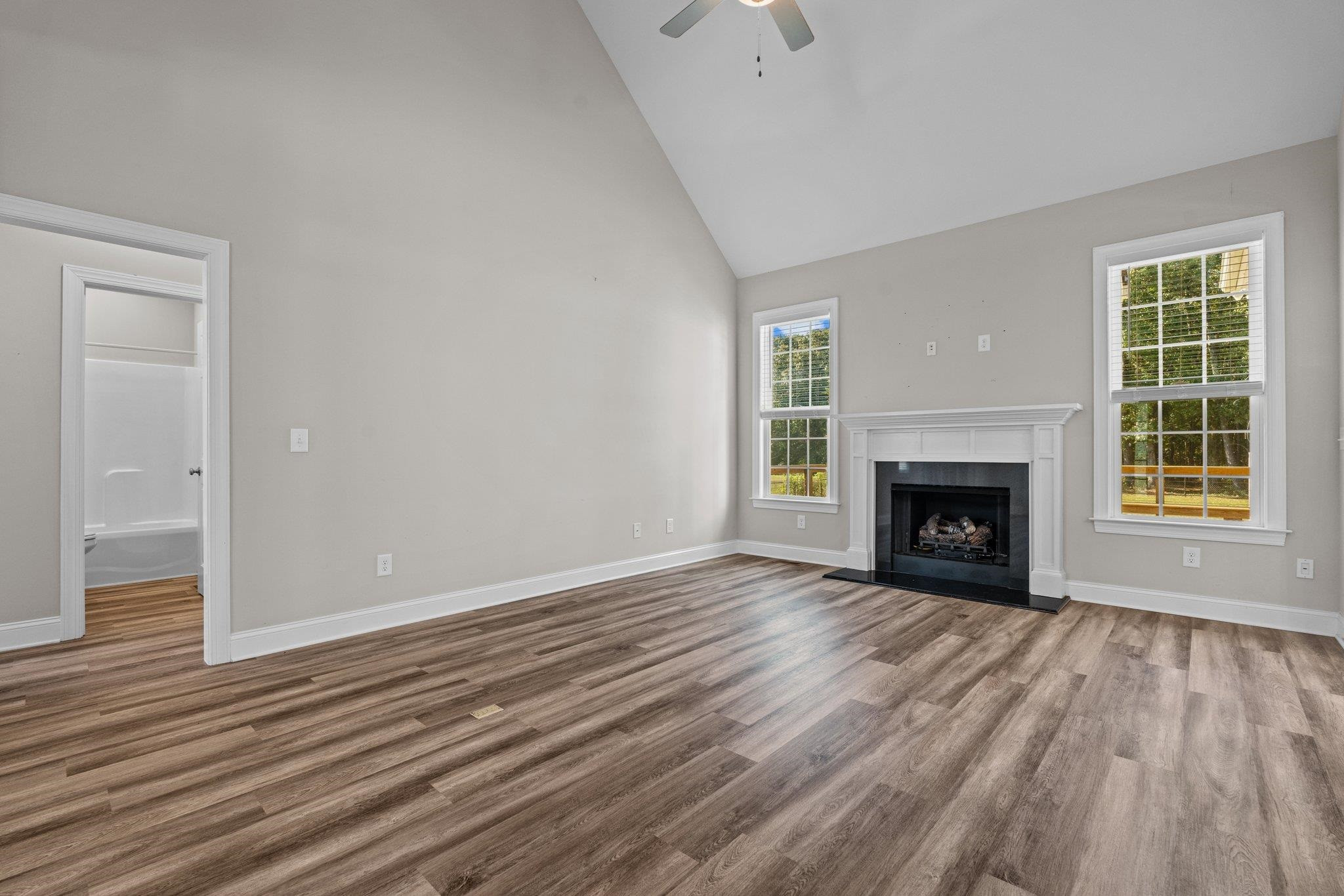 991 Sheriff Johnson Road Lillington, NC 27546 - Photo 18 of 52 an empty room with wooden floor fireplace and windows