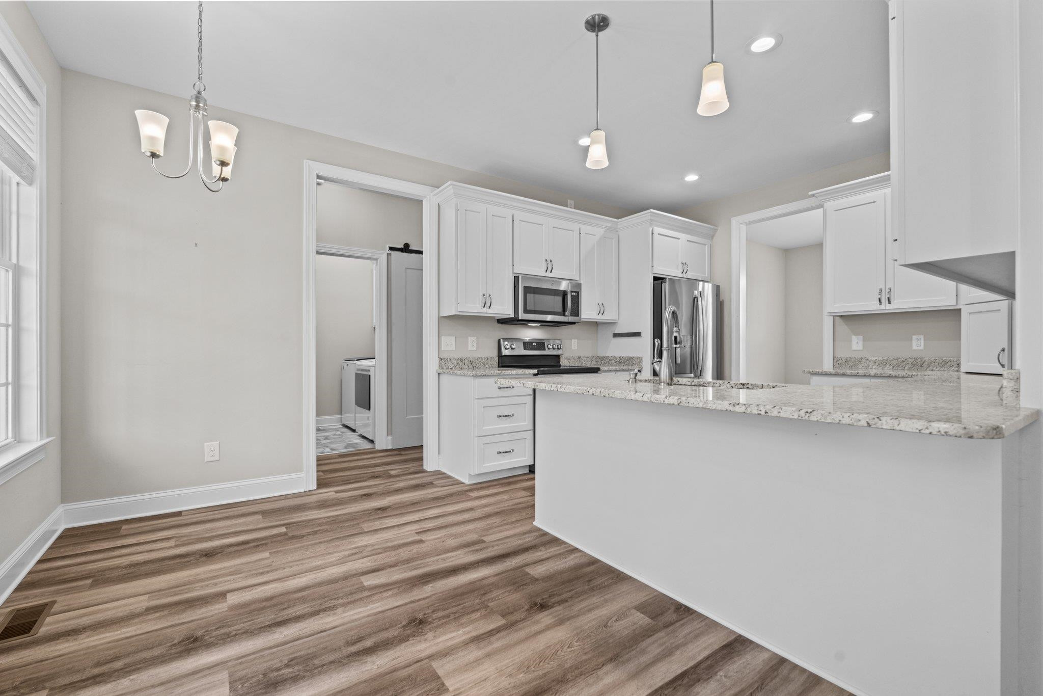 991 Sheriff Johnson Road Lillington, NC 27546 - Photo 27 of 52 a kitchen with stainless steel appliances granite countertop a refrigerator a sink dishwasher a stove and white cabinets with wooden floor