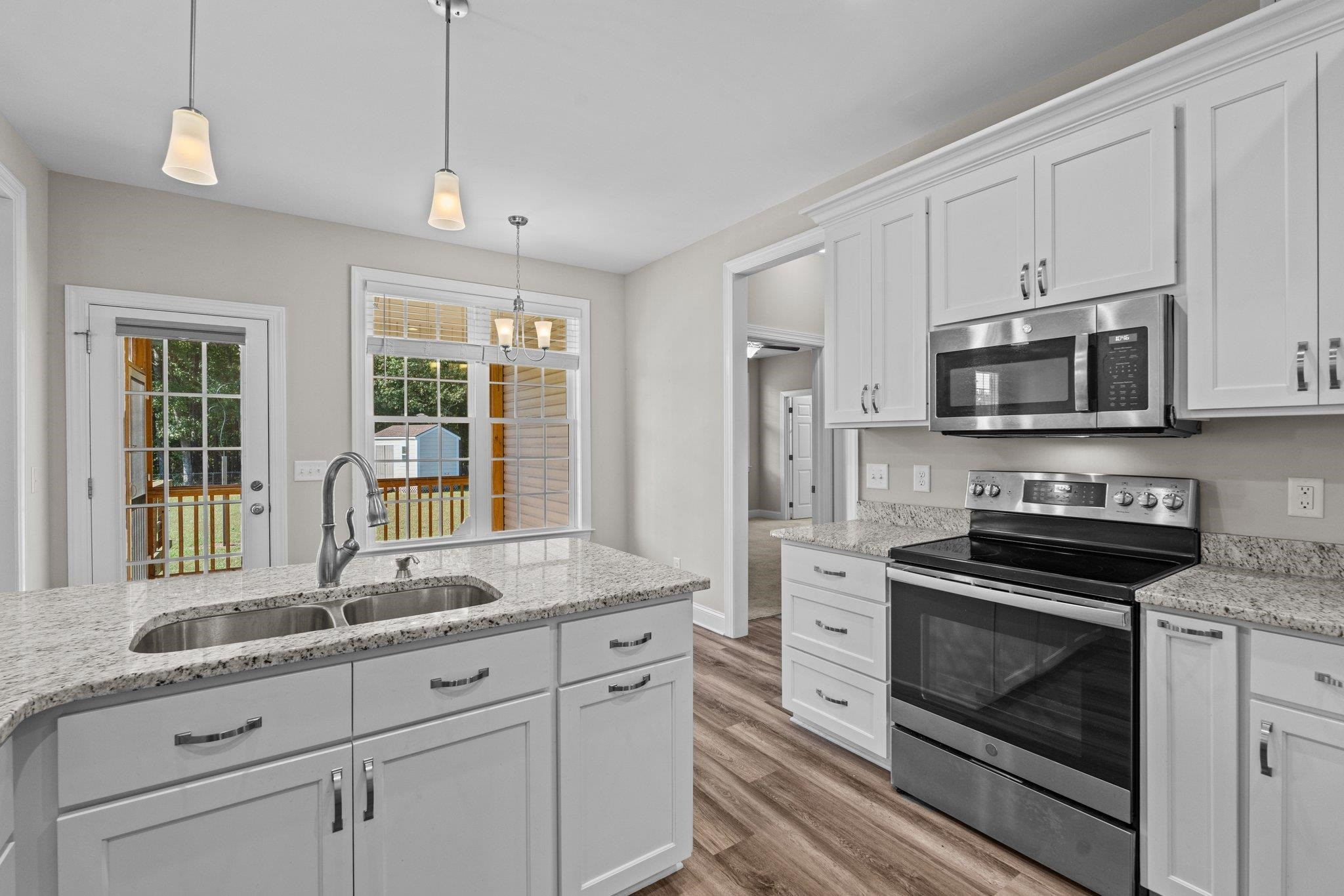 991 Sheriff Johnson Road Lillington, NC 27546 - Photo 29 of 52 a kitchen with granite countertop white cabinets stainless steel appliances and a sink