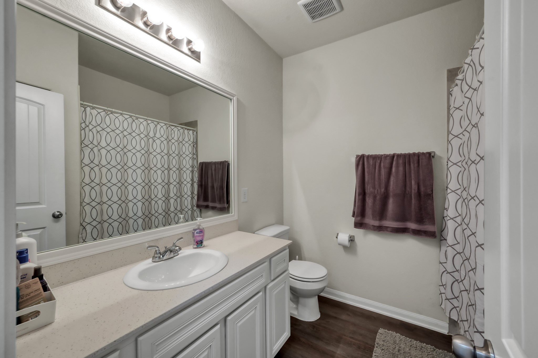 6264 Rolling Hills Road Conroe, TX 77303 - Photo 17 of 24 a bathroom with a granite countertop toilet sink and mirror