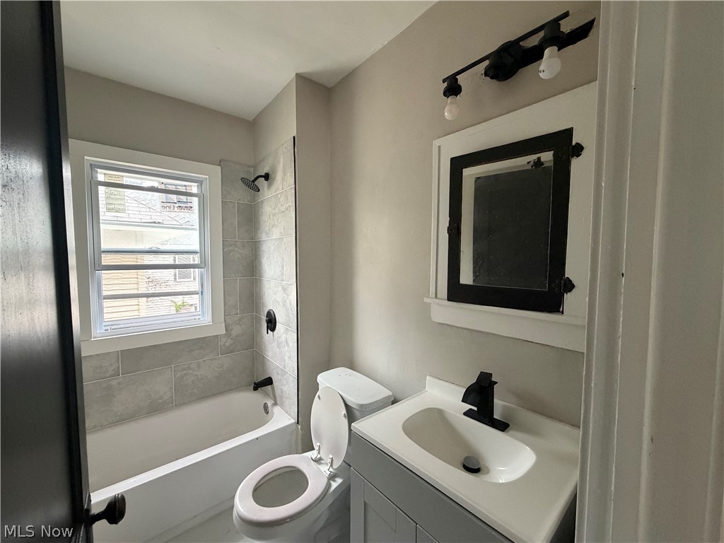 15317 Shiloh Road Cleveland, OH 44110 - Photo 22 of 29 Bathroom featuring a white tub, light gray subway tile shower surround, and a window with white trim