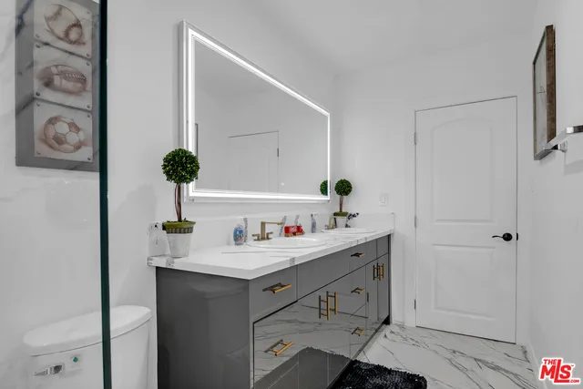 a bathroom with a sink vanity mirror and toilet