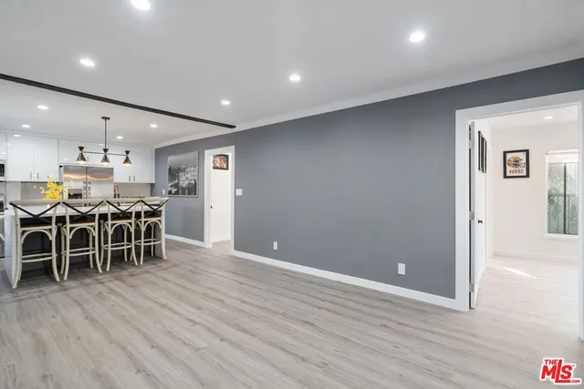 a kitchen with stainless steel appliances kitchen island granite countertop a stove a refrigerator a kitchen island a sink with a dining table and chairs