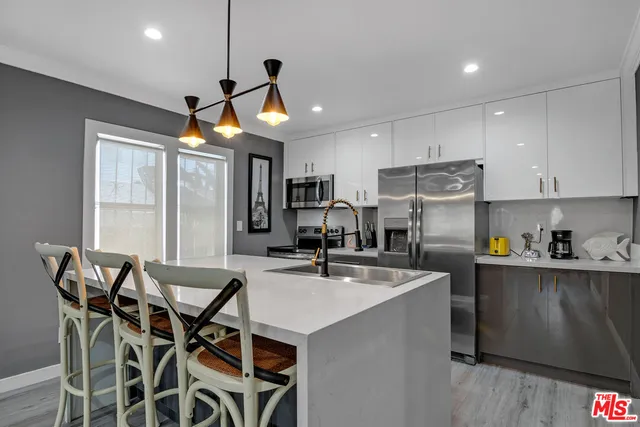 a kitchen with stainless steel appliances granite countertop a stove microwave and refrigerator