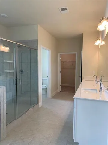 a spacious bathroom with a shower sink and mirror