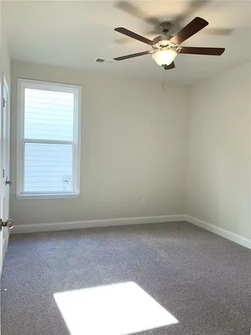 an empty room with a window and a fan