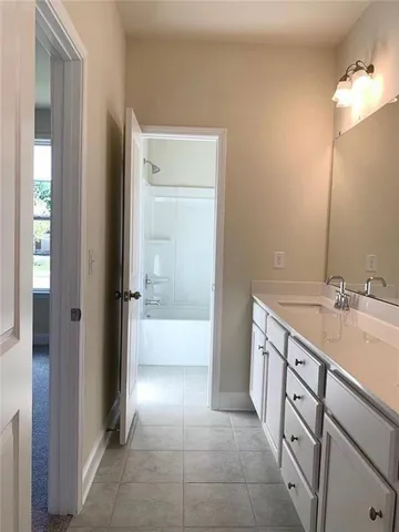a bathroom with a tub sink and mirror