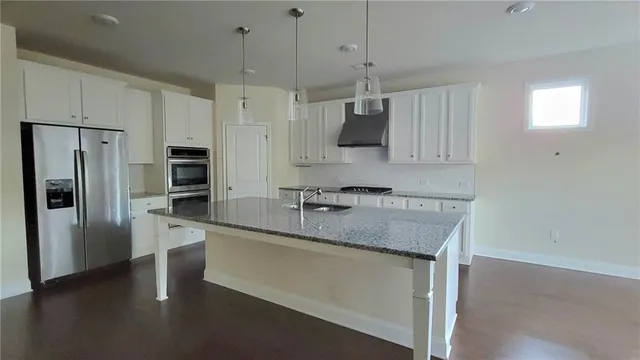 a kitchen with stainless steel appliances granite countertop a sink refrigerator and microwave