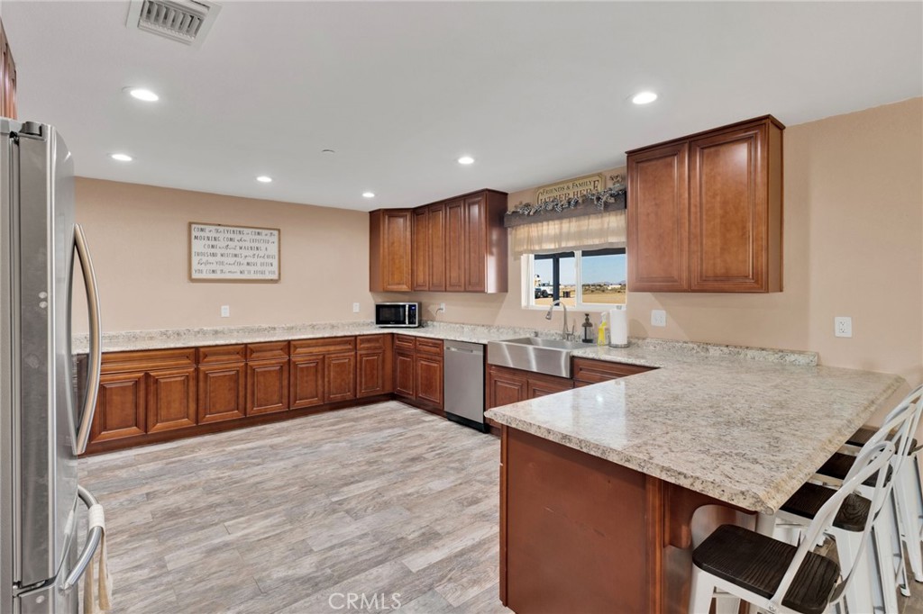 32461 Prairie Avenue Barstow, CA 92311 - Photo 11 of 46 a kitchen with stainless steel appliances granite countertop a kitchen island a cabinets and wooden floor