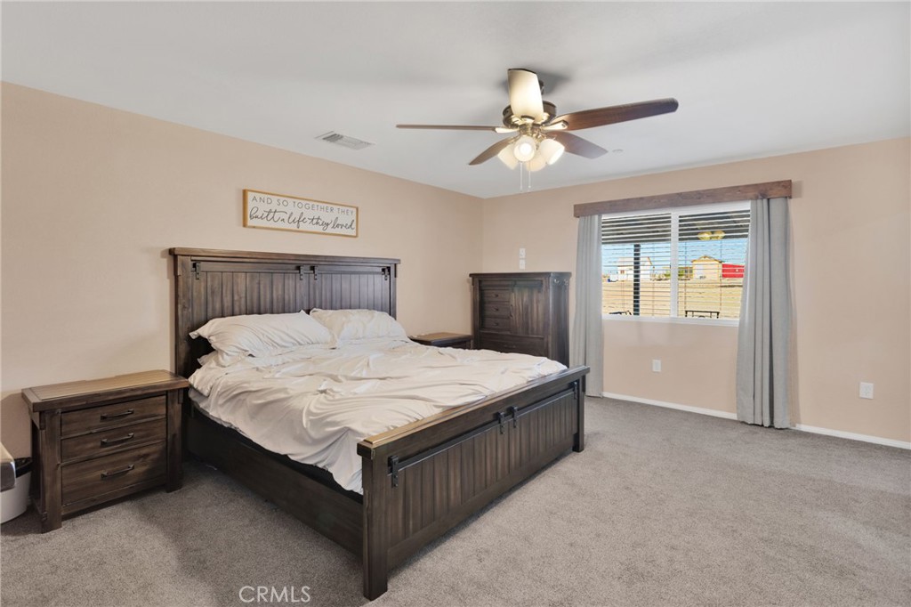 32461 Prairie Avenue Barstow, CA 92311 - Photo 15 of 46 a bedroom with a bed and a chandelier