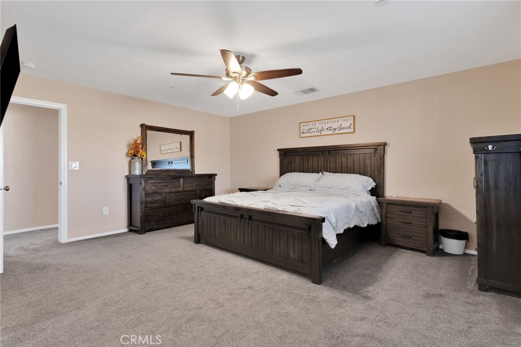 32461 Prairie Avenue Barstow, CA 92311 - Photo 17 of 46 a bedroom with a bed and a chandelier