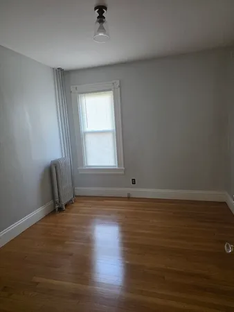 a view of a hallway with wooden floor and closet area