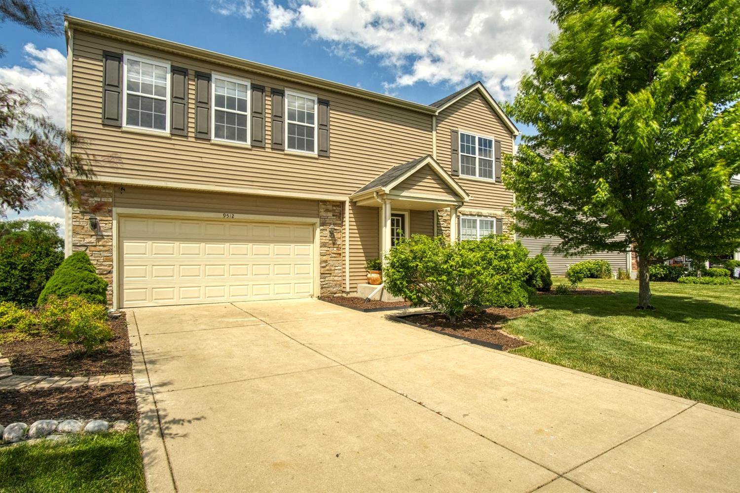 a front view of a house with a yard and garage