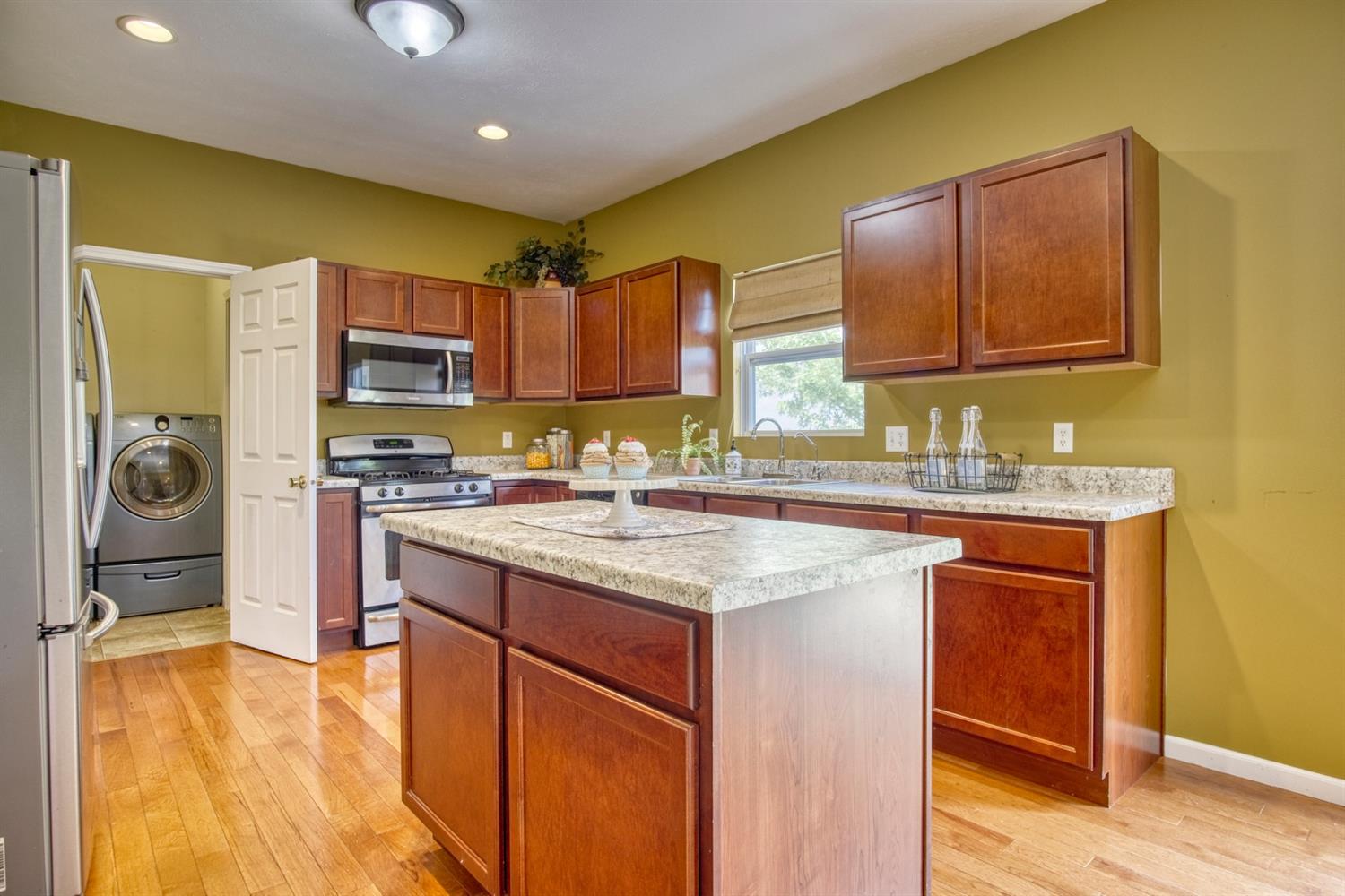 9512 Dewey Place Crown Point, IN 46307 - Photo 5 of 27 a kitchen with stainless steel appliances granite countertop a sink stove and refrigerator
