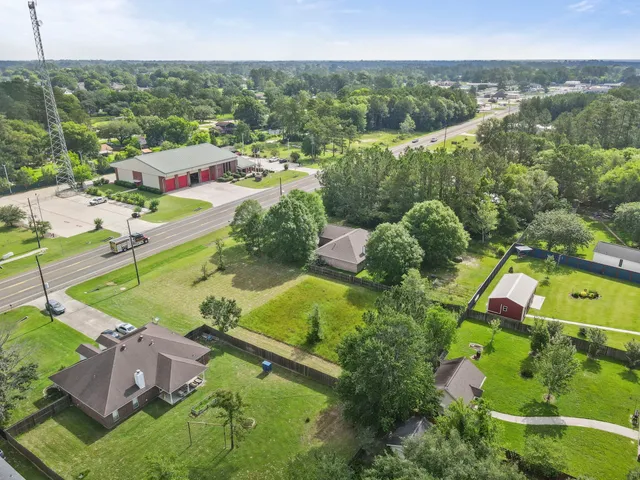an aerial view of residential houses with outdoor space and trees