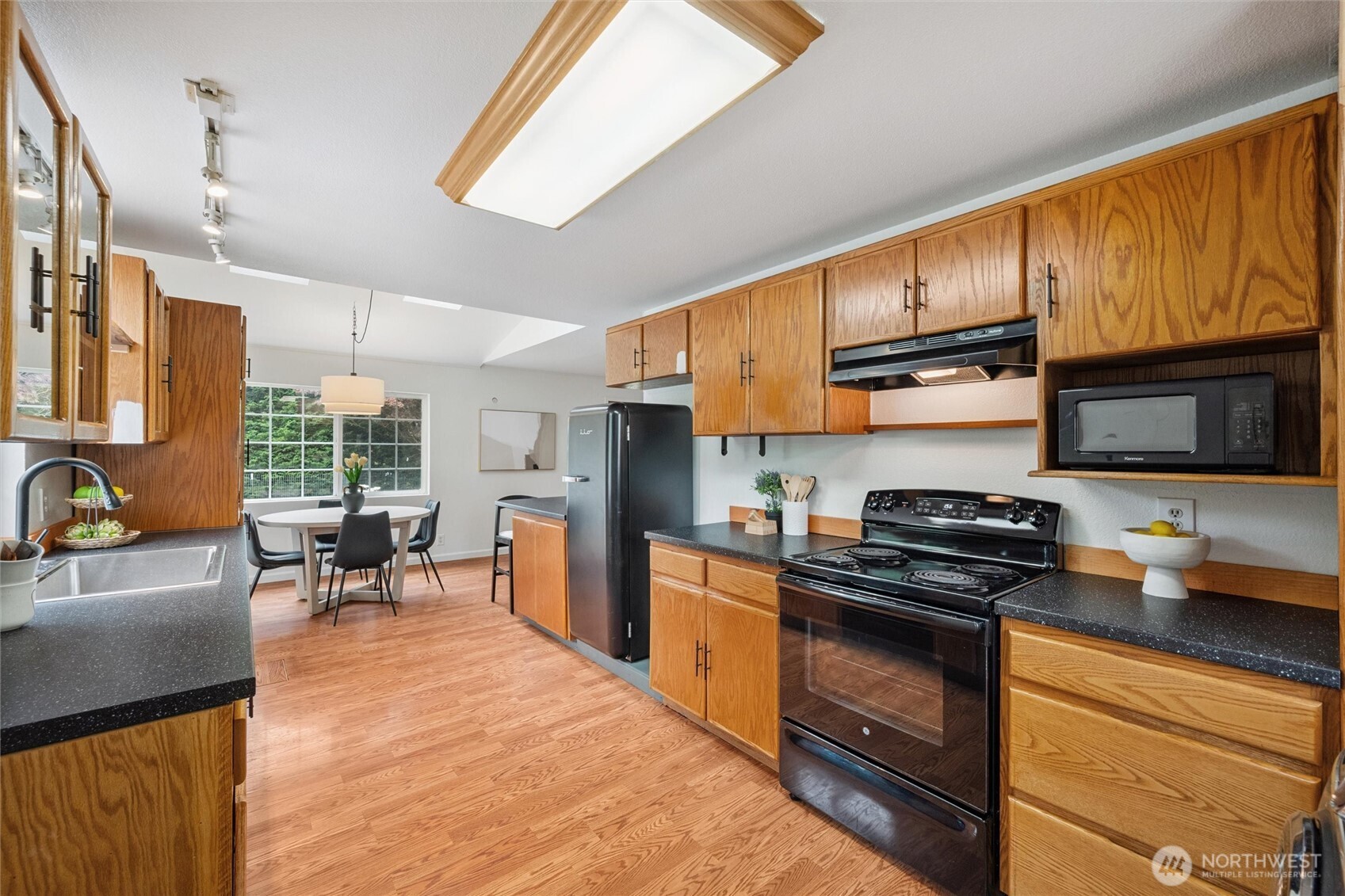 1264 Birch Bay Lynden Road Lynden, WA 98264 - Photo 5 of 38 a kitchen with stainless steel appliances granite countertop a stove top oven a sink dishwasher a dining table and chairs with wooden floor