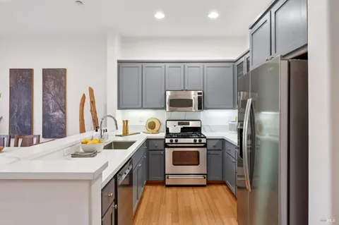 a kitchen with stainless steel appliances a stove refrigerator sink and microwave