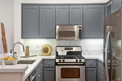 a kitchen with appliances a sink and cabinets