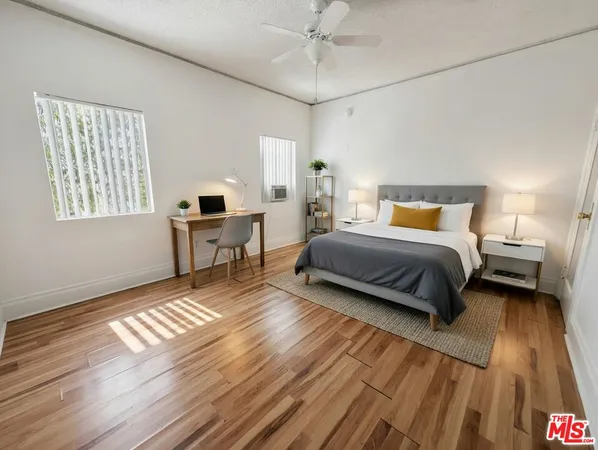 a bedroom with a bed and wooden floor