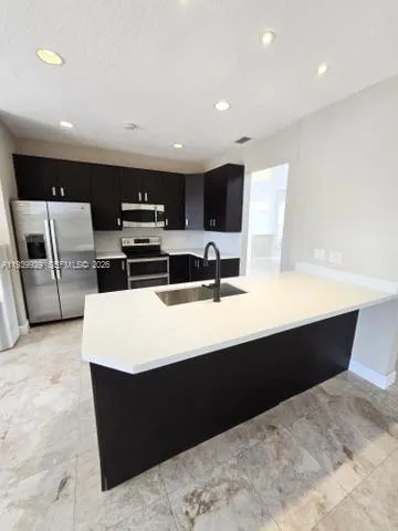 a kitchen with stainless steel appliances a sink and a refrigerator
