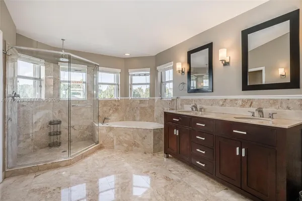 a spacious bathroom with a granite countertop sink mirror and shower