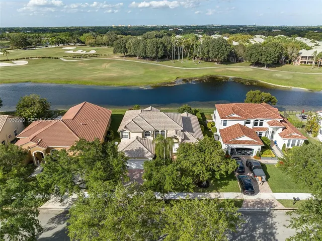 an aerial view of a house with a garden and lake view