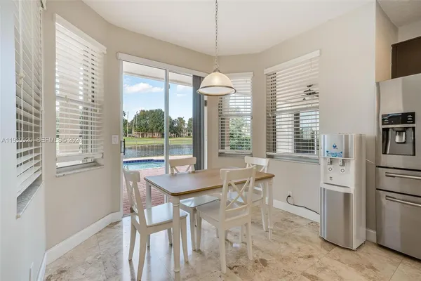 a dining room with furniture large windows and a chandelier