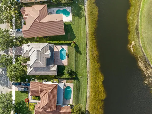 an aerial view of a house with a yard swimming pool and outdoor seating