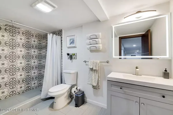 a bathroom with a toilet sink and a mirror